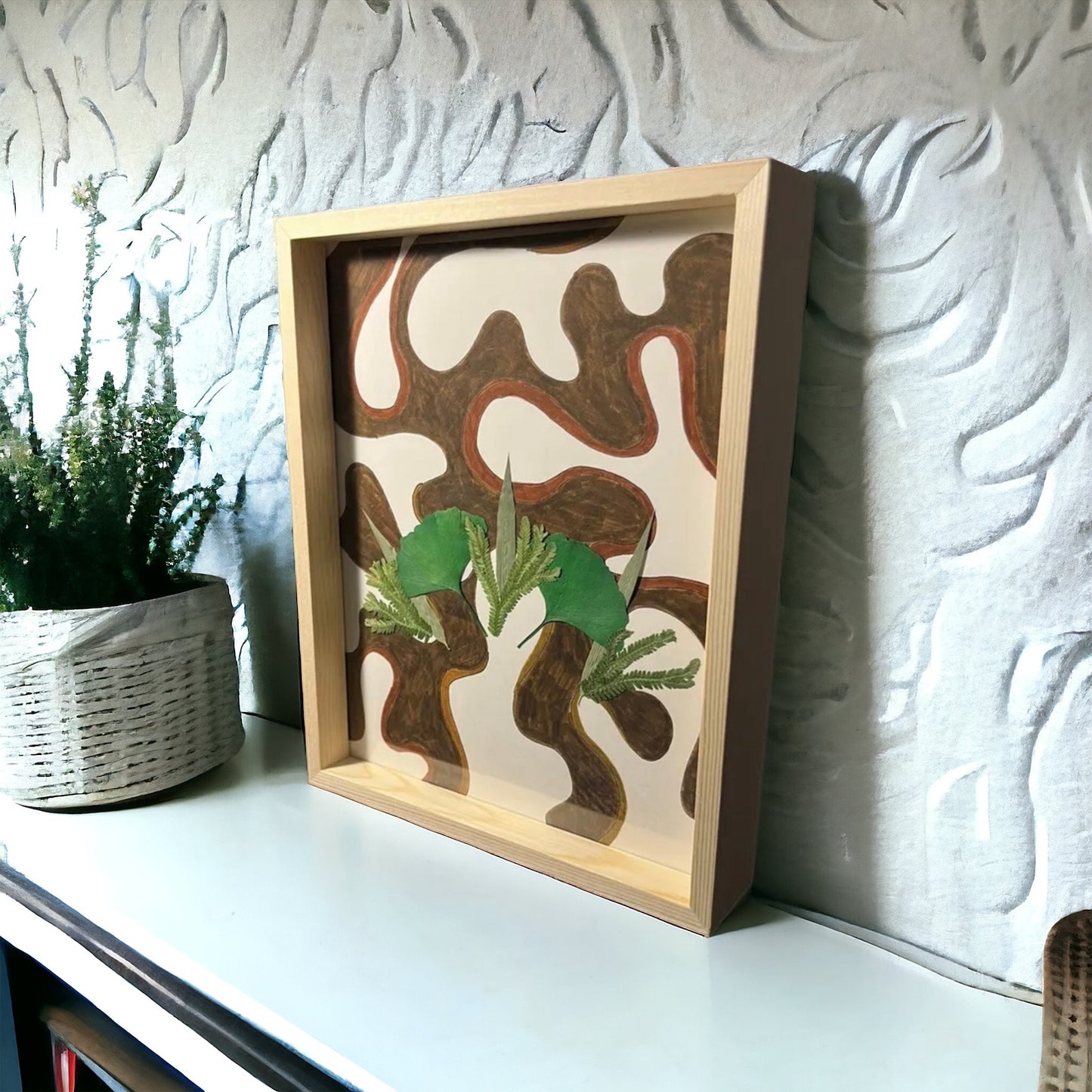 Brown abstract flower art sitting on white shelf