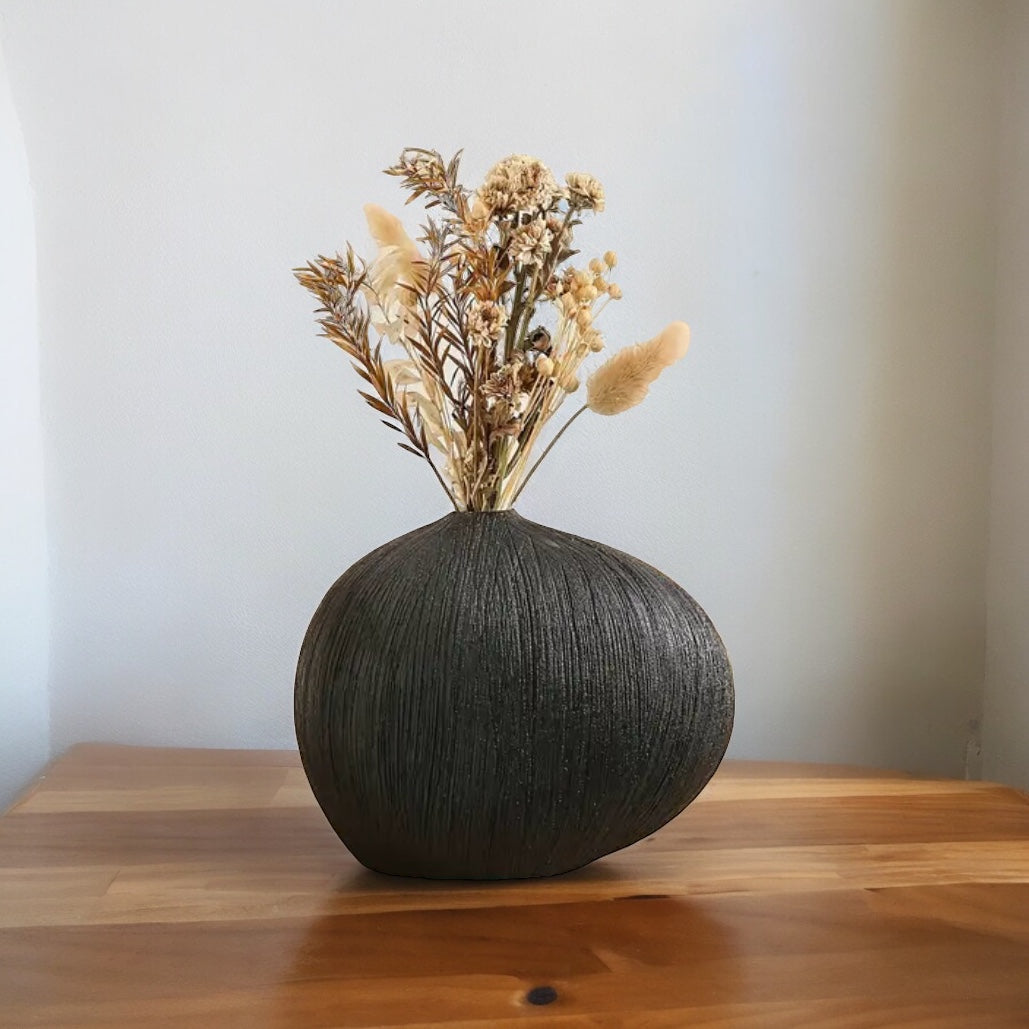 front of teardrop vase with dried flowers inside